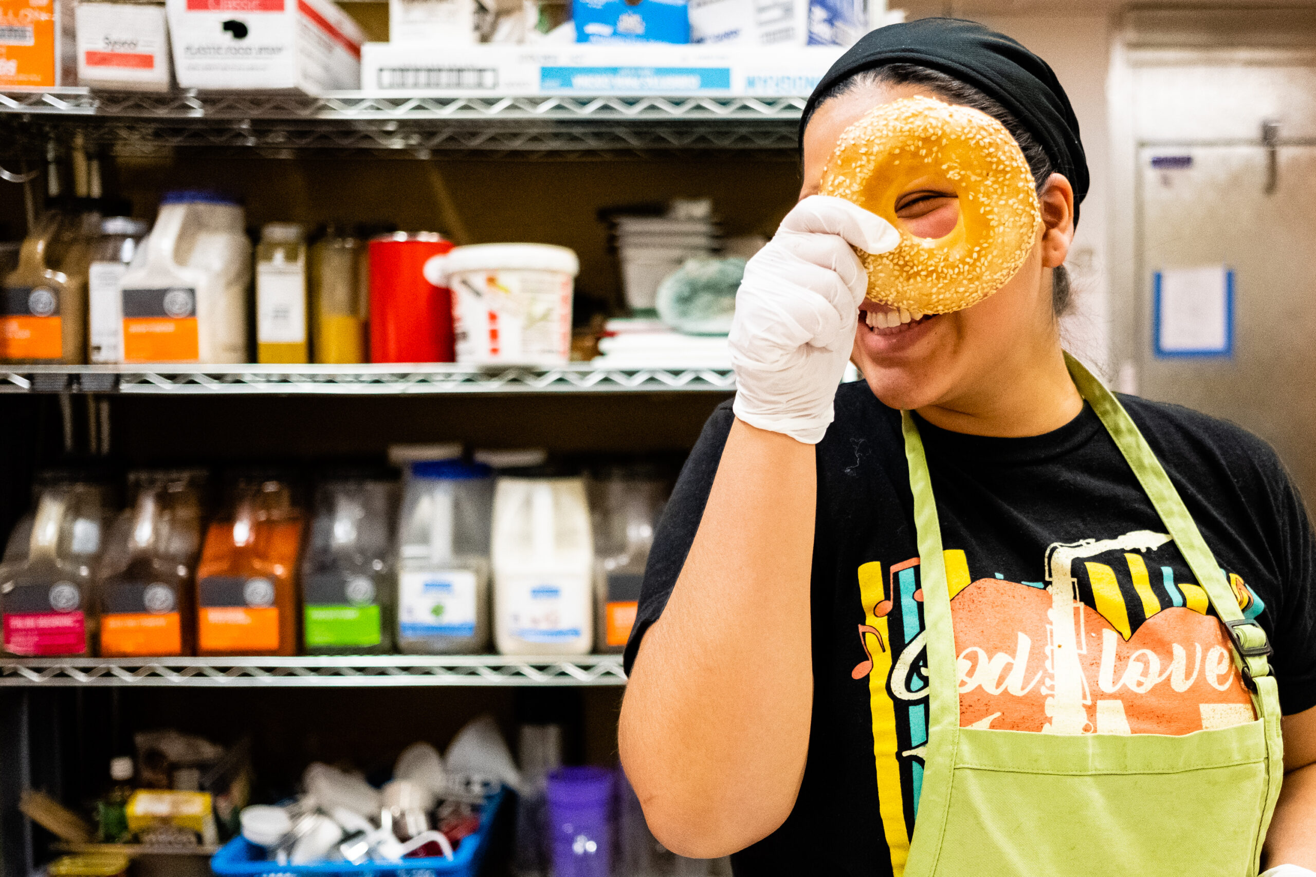 Prep Chef/Kitchen Assistant Michelle peers through a bagel.