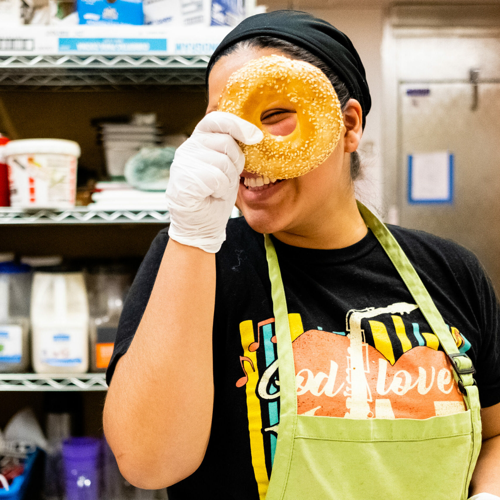 Prep Chef/Kitchen Assistant Michelle peers through a bagel.