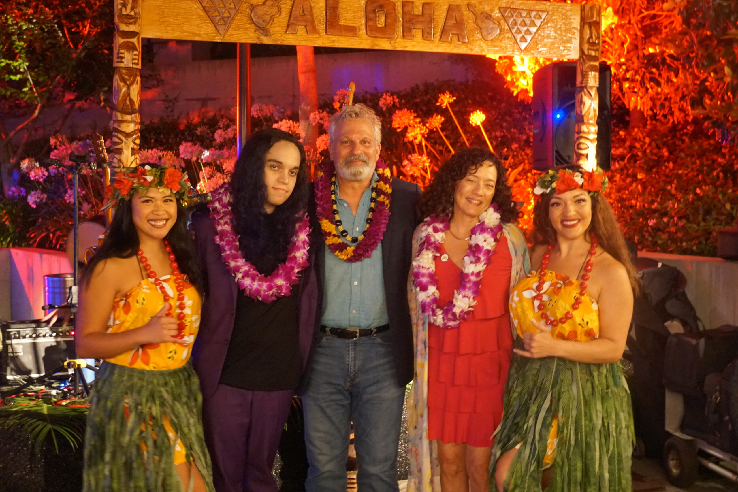Jonathan (middle) with his wife Monica (right), child Jobim (left), and hula dancers