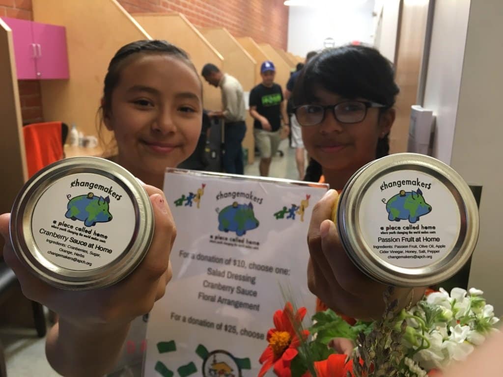 Changemakers Cranberry Sauce jars held up by two young girls